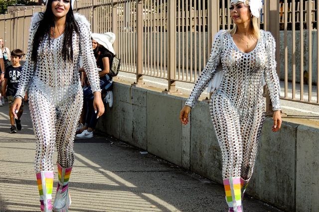 women in silver angel costumes walking across the Brooklyn Bridge